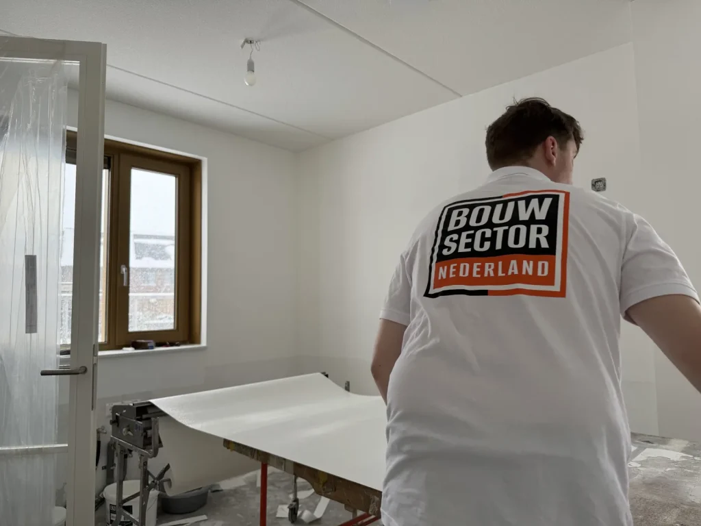 Behanger van Bouwsector Nederland aan het werk met een baan vlies op de plaktafel